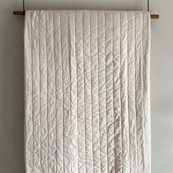 Senses quiltet sengetæppe i beige 260×260 cm fra MOUD Home
